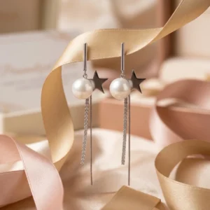 Moonlight Star Danglers: Silver Star Pearl Drop Earrings featuring a silver star, a large white pearl, and long cascading silver chains on a marble surface.